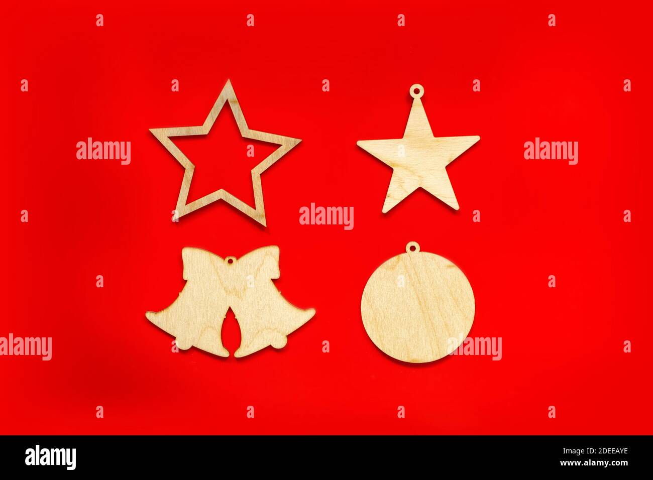 Christmas wooden decorations in the form of stars, bells and ball, on a red background Stock Photo