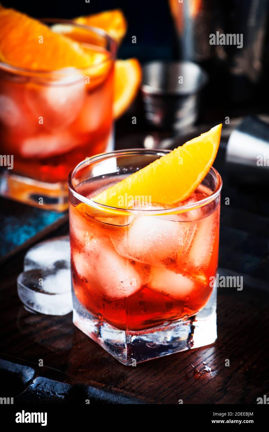 Summer alcoholic cocktail Negroni with dry gin, red vermouth and red bitter, orange slice and