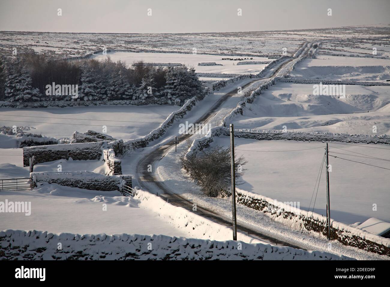 February and a heavy snowfall covers the land and single track road in the Yorkshire Dales Stock Photo