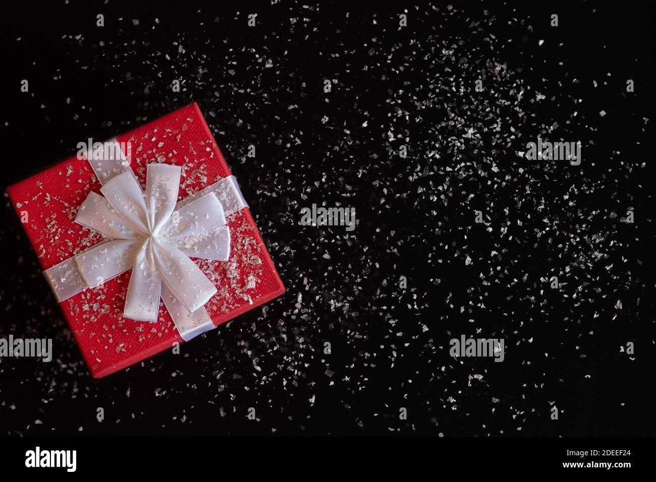 Red gift box with a white bow on a black background Stock Photo