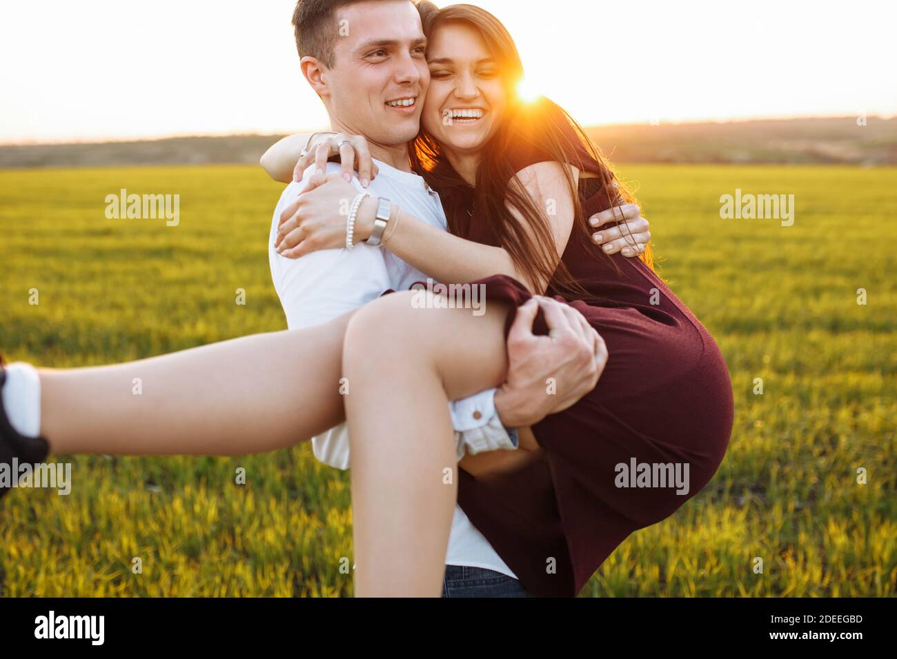 young, happy, loving couple, outdoors, man holding a girl in his arms ...