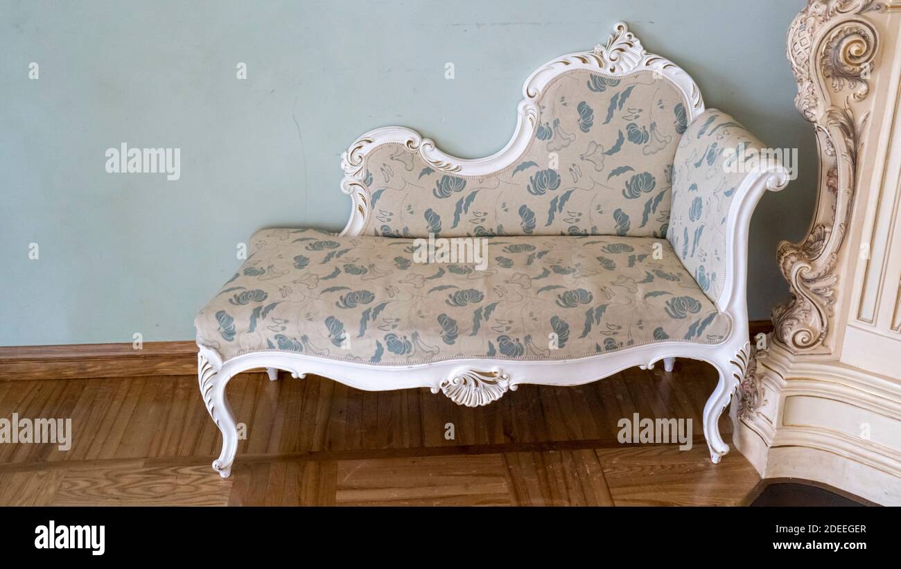 Vintage Wooden Classical Carved Sofa Upholstered in a Beautiful Cloth. Retro Style. Furniture for Refined Interior. Old, Palace Furniture. Stock Photo