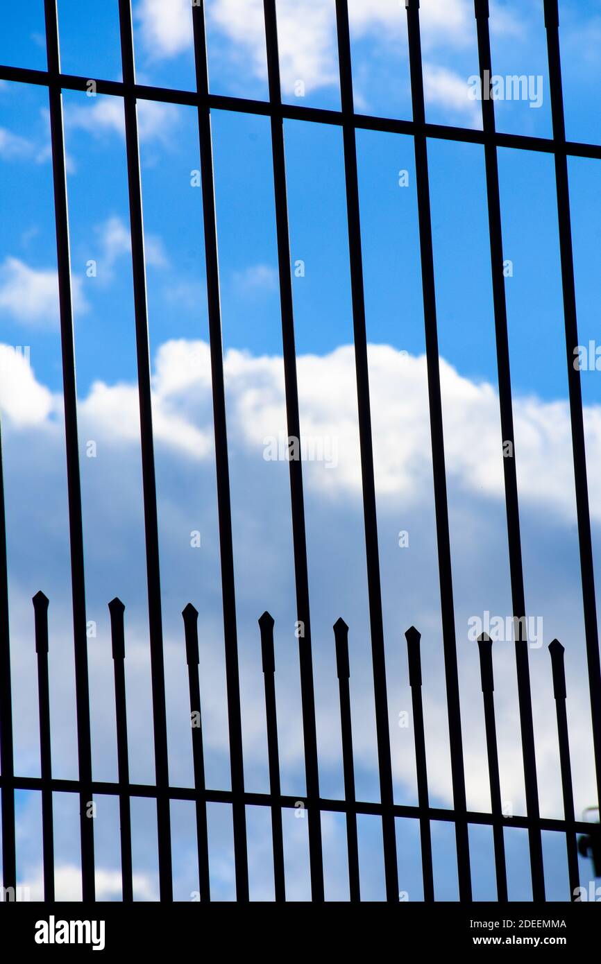 Metal fence. White clouds and blue sky Stock Photo - Alamy