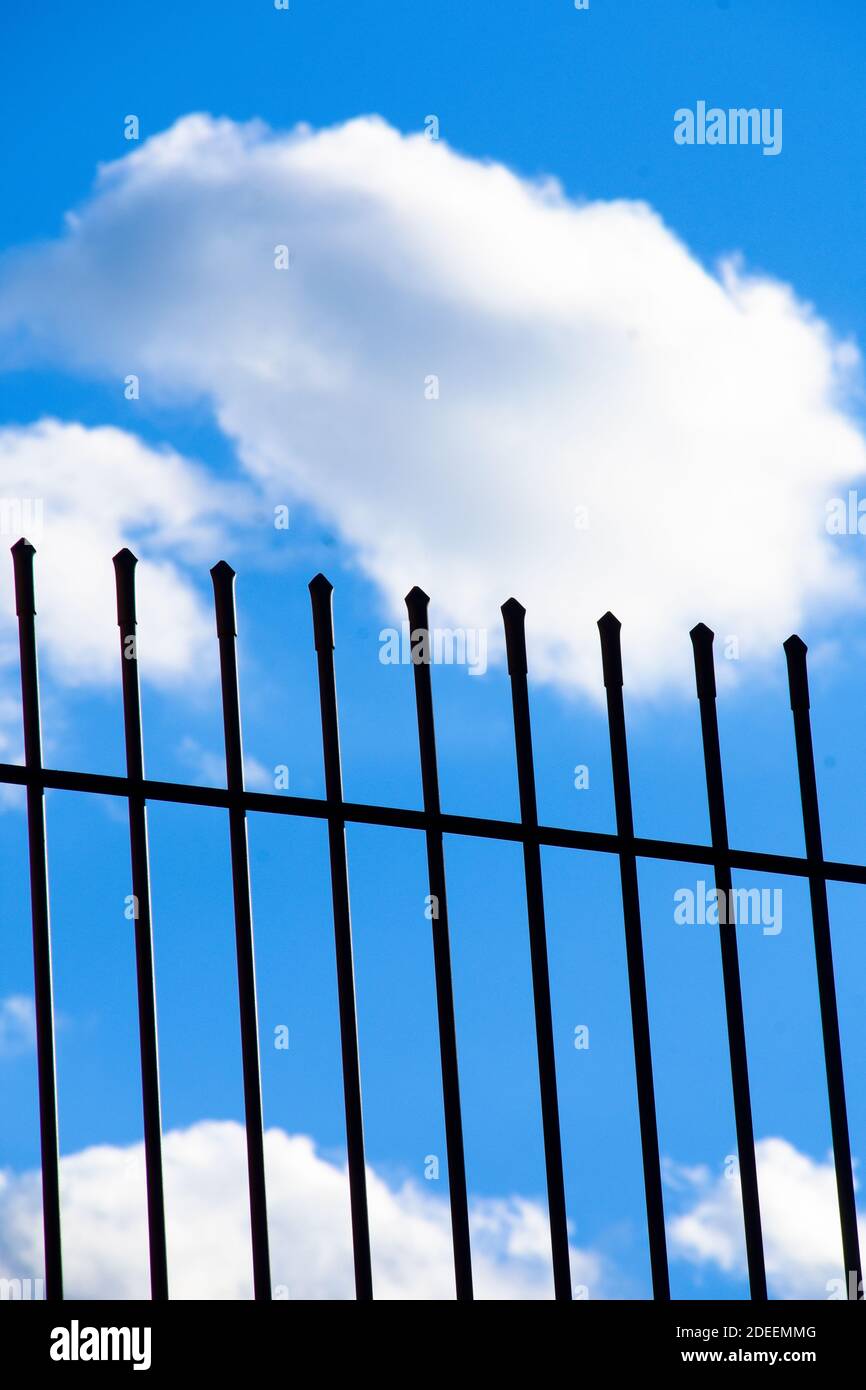 Metal fence. White clouds and blue sky Stock Photo - Alamy