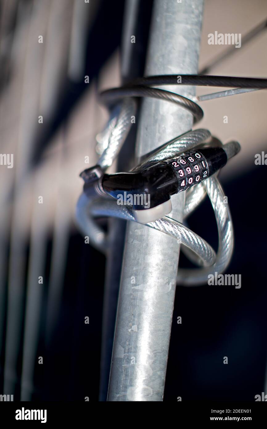 bicycle lock with numeric code attached to a metal grille Stock Photo
