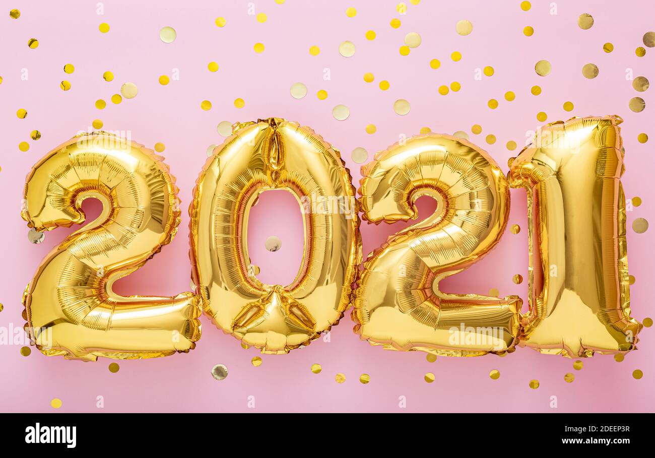 2021 Happy New year eve invitation. 2021 Golden air balloon numbers on pink background with confetti. Stock Photo
