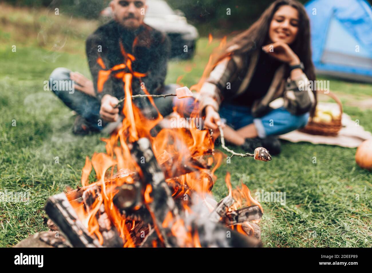 Beautiful couple roasting marshmallows over the campfire Stock Photo
