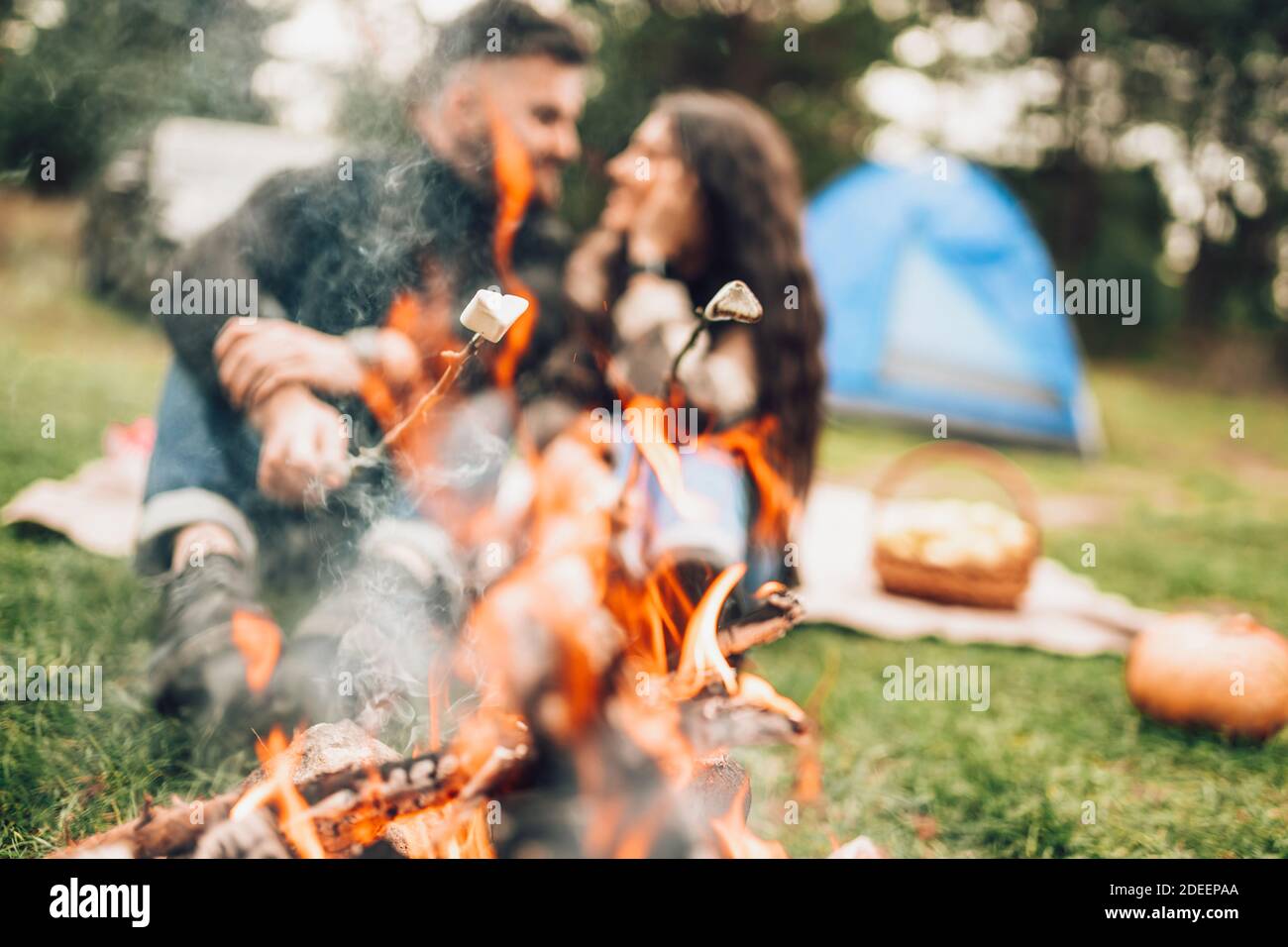 Beautiful couple roasting marshmallows over the campfire Stock Photo