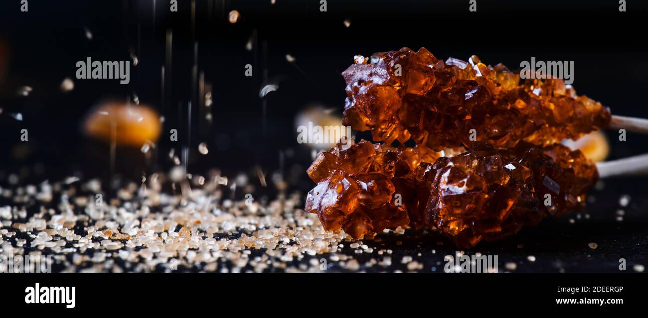 Candy cane sugar, brown sugar sticks on a dark table, selective focus Stock Photo