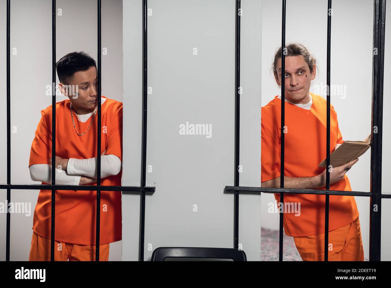 Two ethical prisoners talk through the bars of neighboring cells in the ...