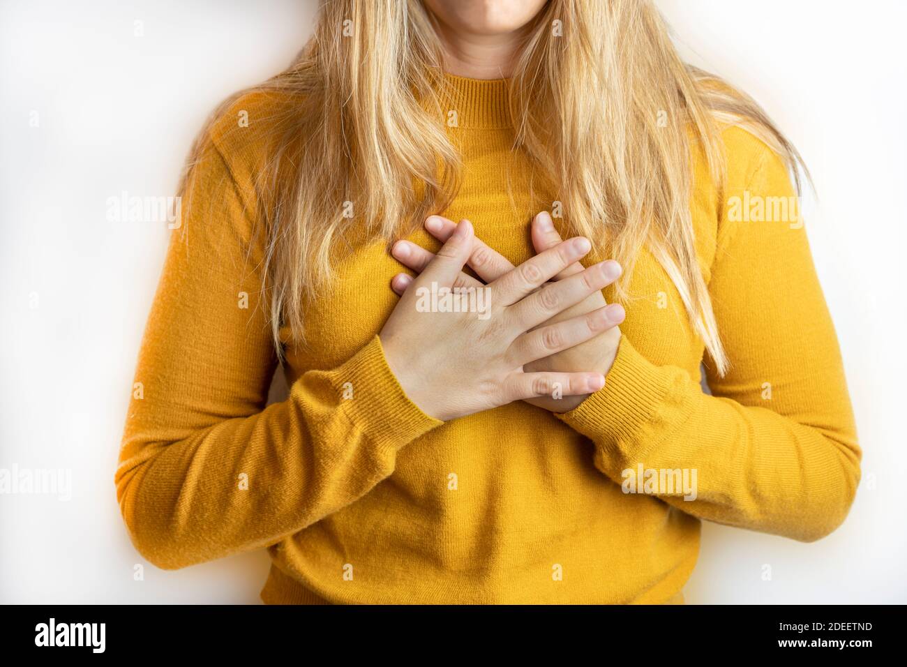 Young woman crossing her hands on chest isolated on white background.Concept of peace ,gratitude, happiness, love and friendship lifestyle mockup. Stock Photo