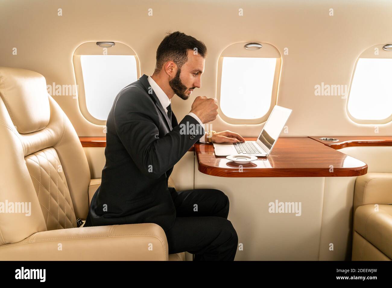 Handsome businessman wearing elegant suit flying on exclusive private
