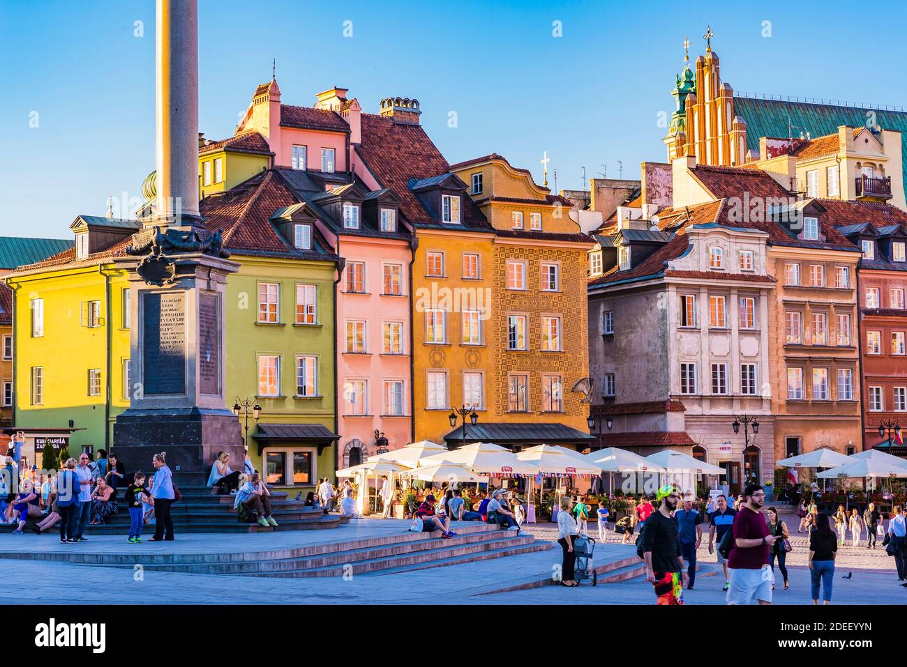 Tourists and locals relaxing in Castle Square at sunset, Old Town. Warsaw, Poland, Europe Stock Photo