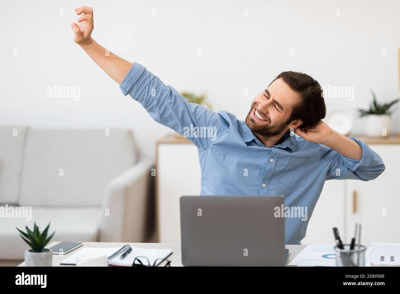 Man Massaging Aching Neck After Work At Computer In Office Stock Photo