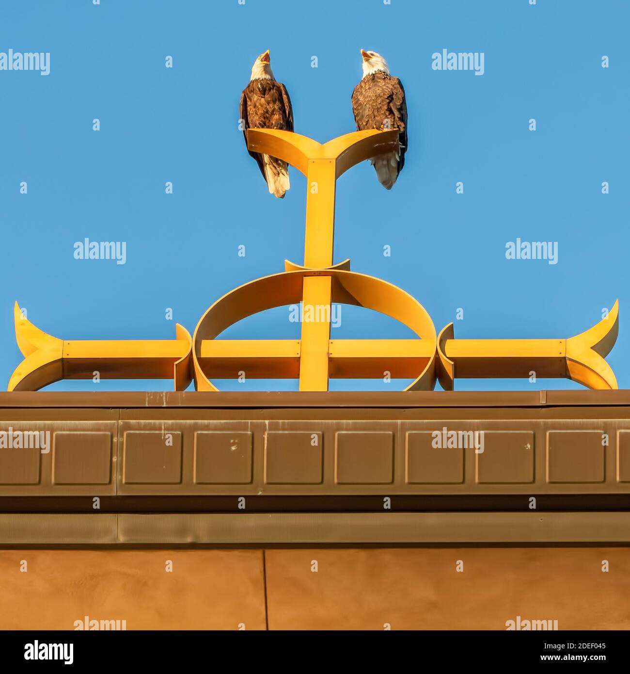 Two bald eagles on Catholic church steeple on top of the Christian cross at Annunciation Church in South Minneapolis Stock Photo