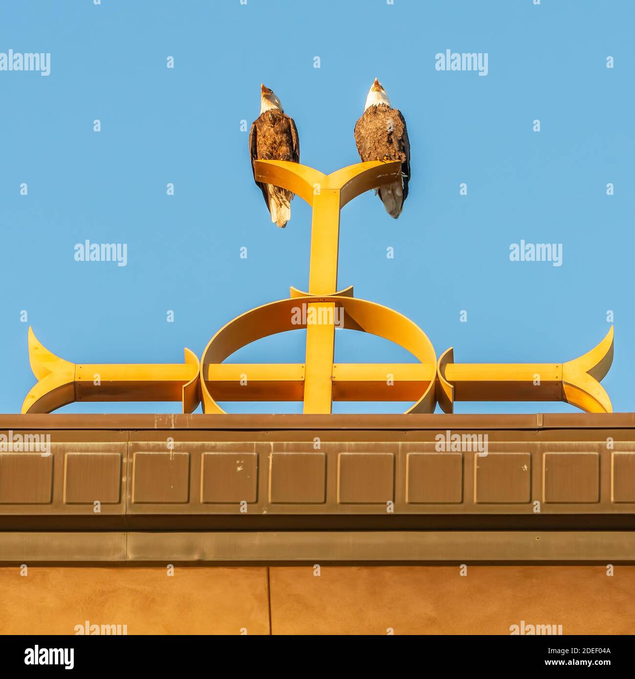Two bald eagles on Catholic church steeple on top of the Christian cross at Annunciation Church in South Minneapolis Stock Photo