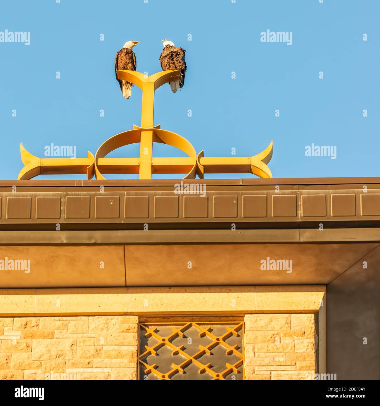 Two bald eagles on Catholic church steeple on top of the Christian cross at Annunciation Church in South Minneapolis Stock Photo
