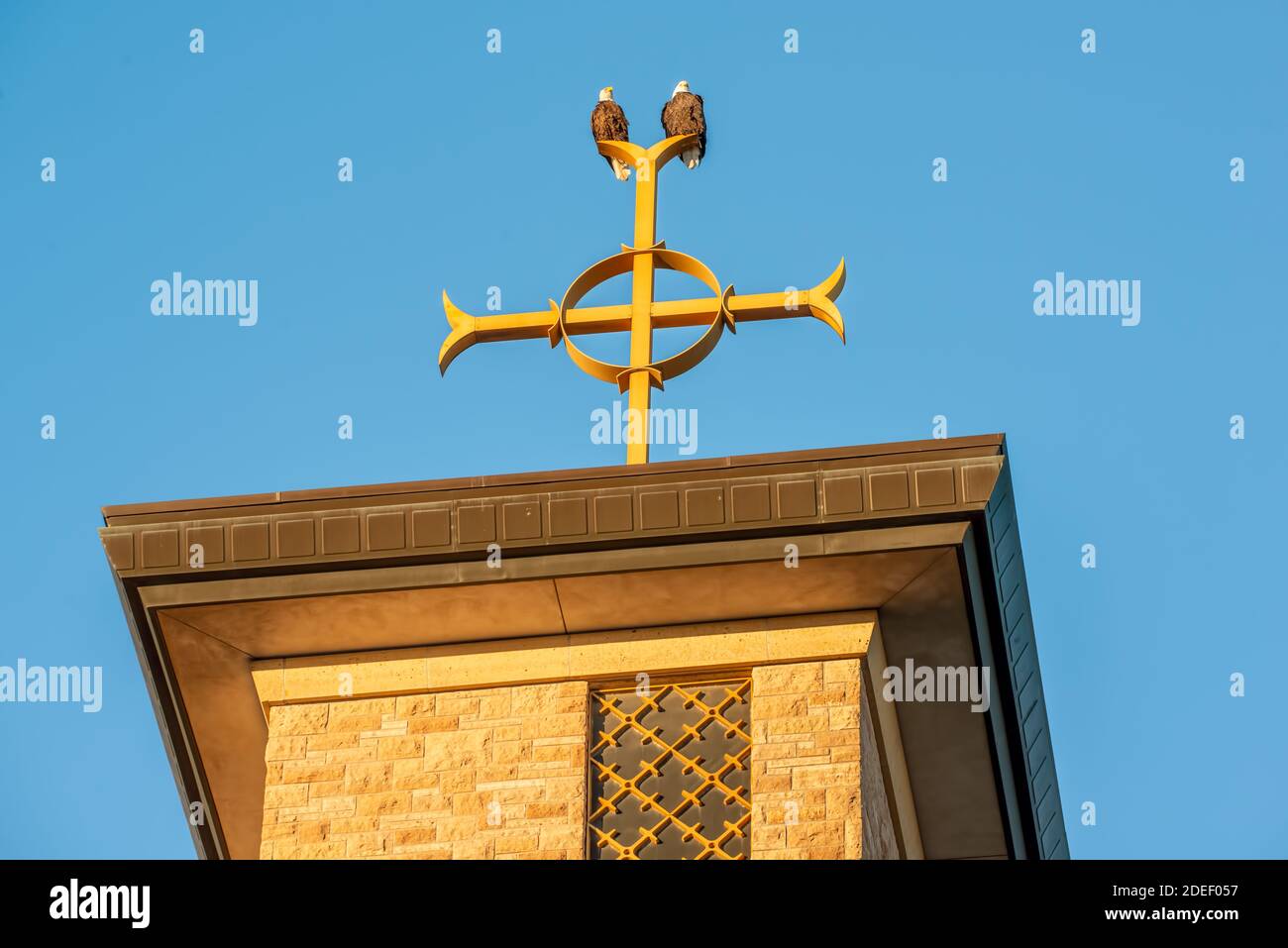 Two bald eagles on Catholic church steeple on top of the Christian cross at Annunciation Church in South Minneapolis Stock Photo