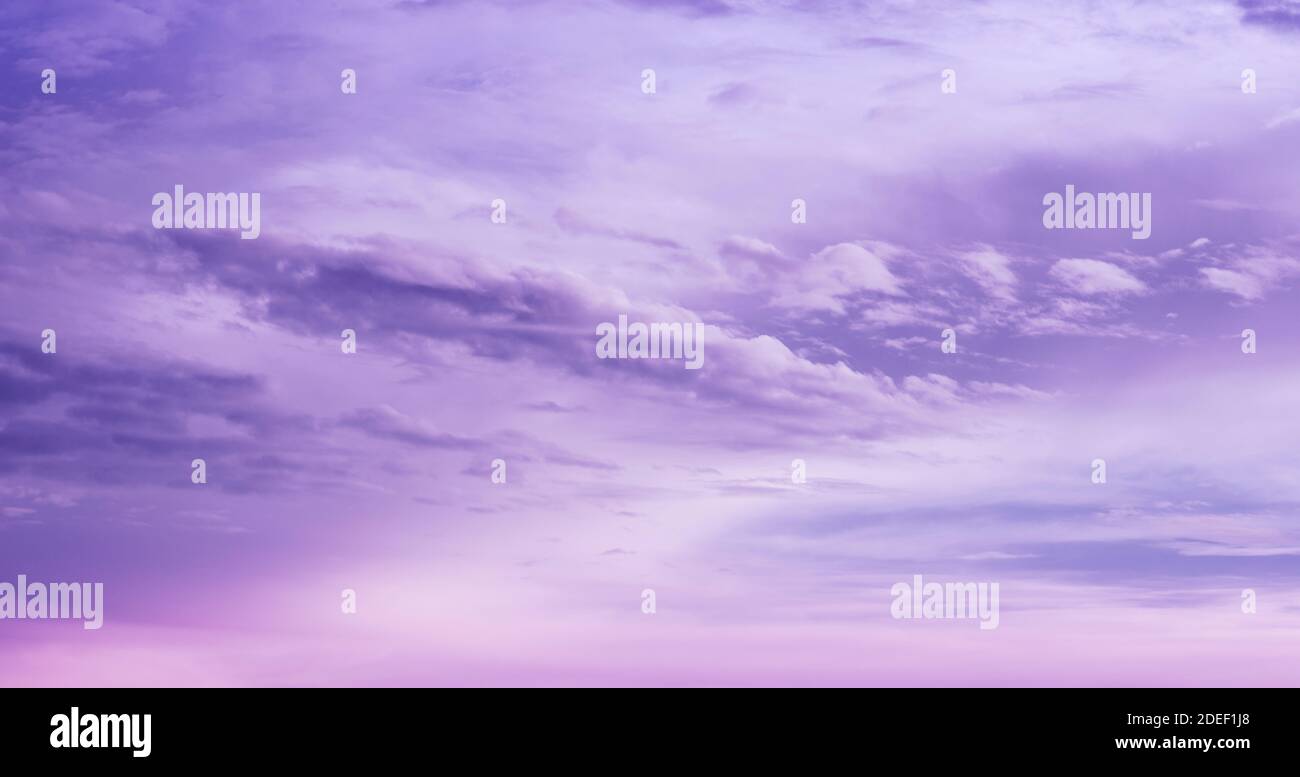 Beautiful purple sky background. Soft white clouds at sunset. Many pink and magenta tones and patterns of clouds. Stock Photo