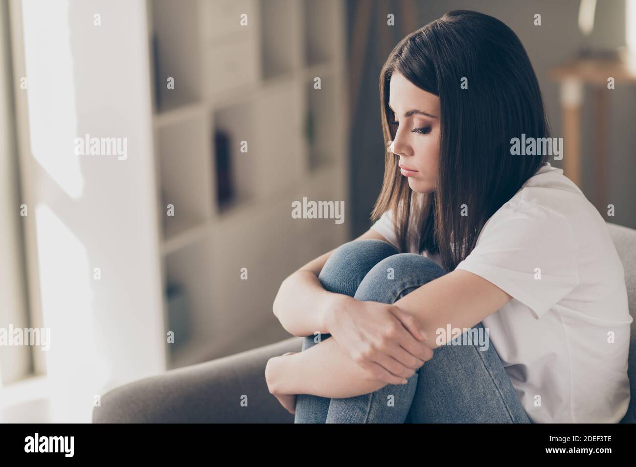 Profile side photo of attractive young girl feeling upset hug her knees ...