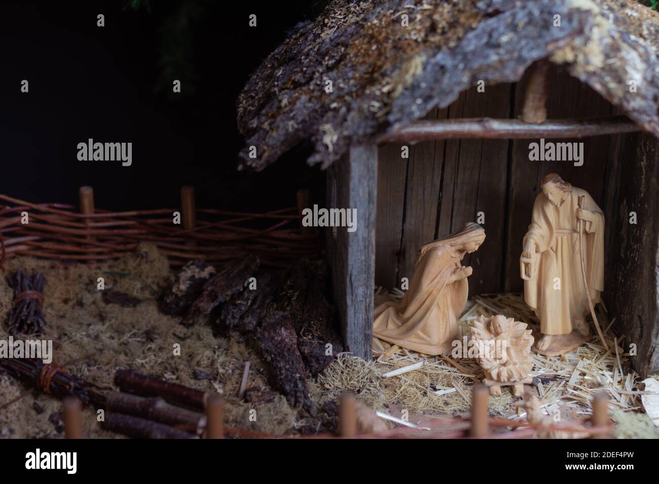Christmas Nativity Scene, Mary, Joseph and Baby Jesus, wood carved figurines in rustic wood stable, copy space, background Stock Photo