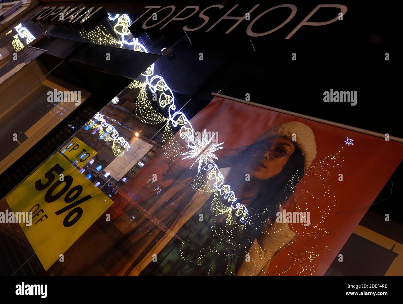 Loughborough, Leicestershire, UK. 30th November 2020. Christmas decorations  are reflected in the window of a Topman and Topshop store after the Arcadia  Group entered into administration putting 13,000 jobs at risk. Credit