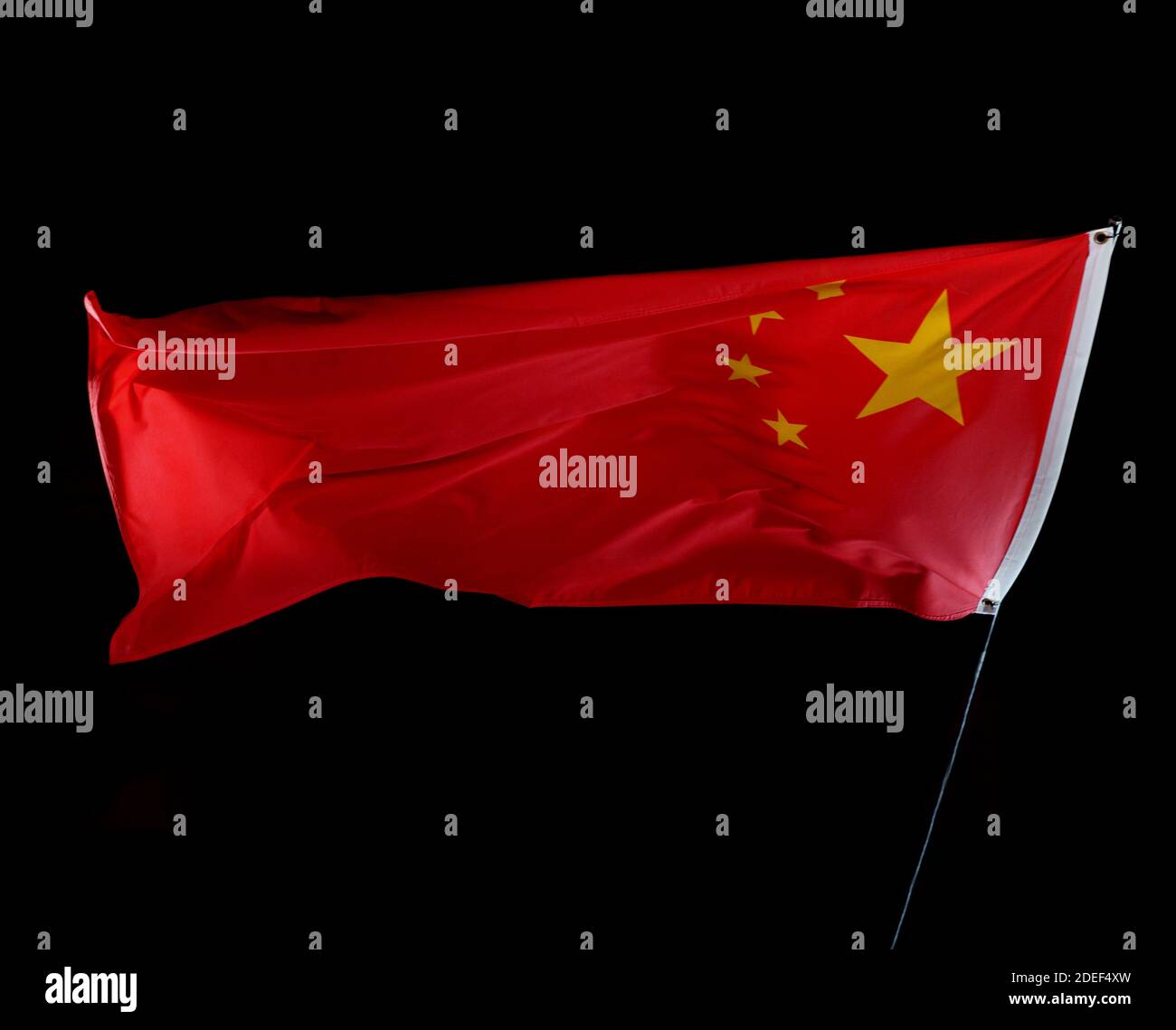 Chinese flag blowing in the wind isolated against a black background, studio shot. Stock Photo