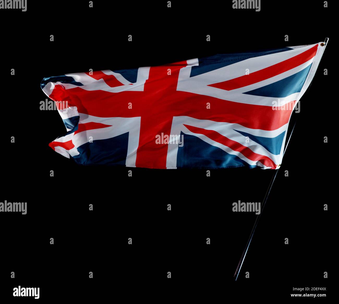 United Kingdom flag blowing in the wind isolated against a black background, studio shot. Stock Photo