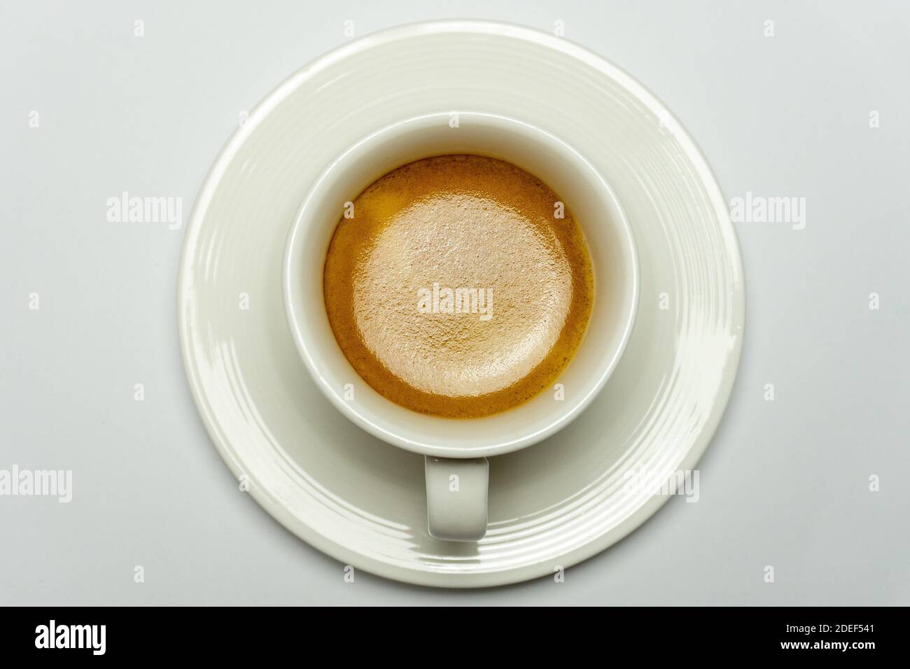 Directly above shot of espresso coffee in white cup on white background. Minimal food background Stock Photo