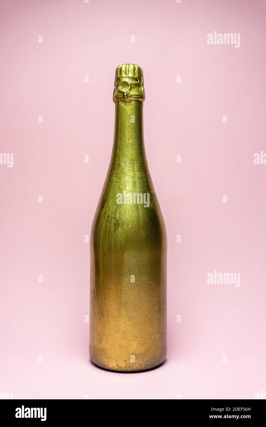 Golden champagne bottle on pink background. Minimal celebration concept Stock Photo