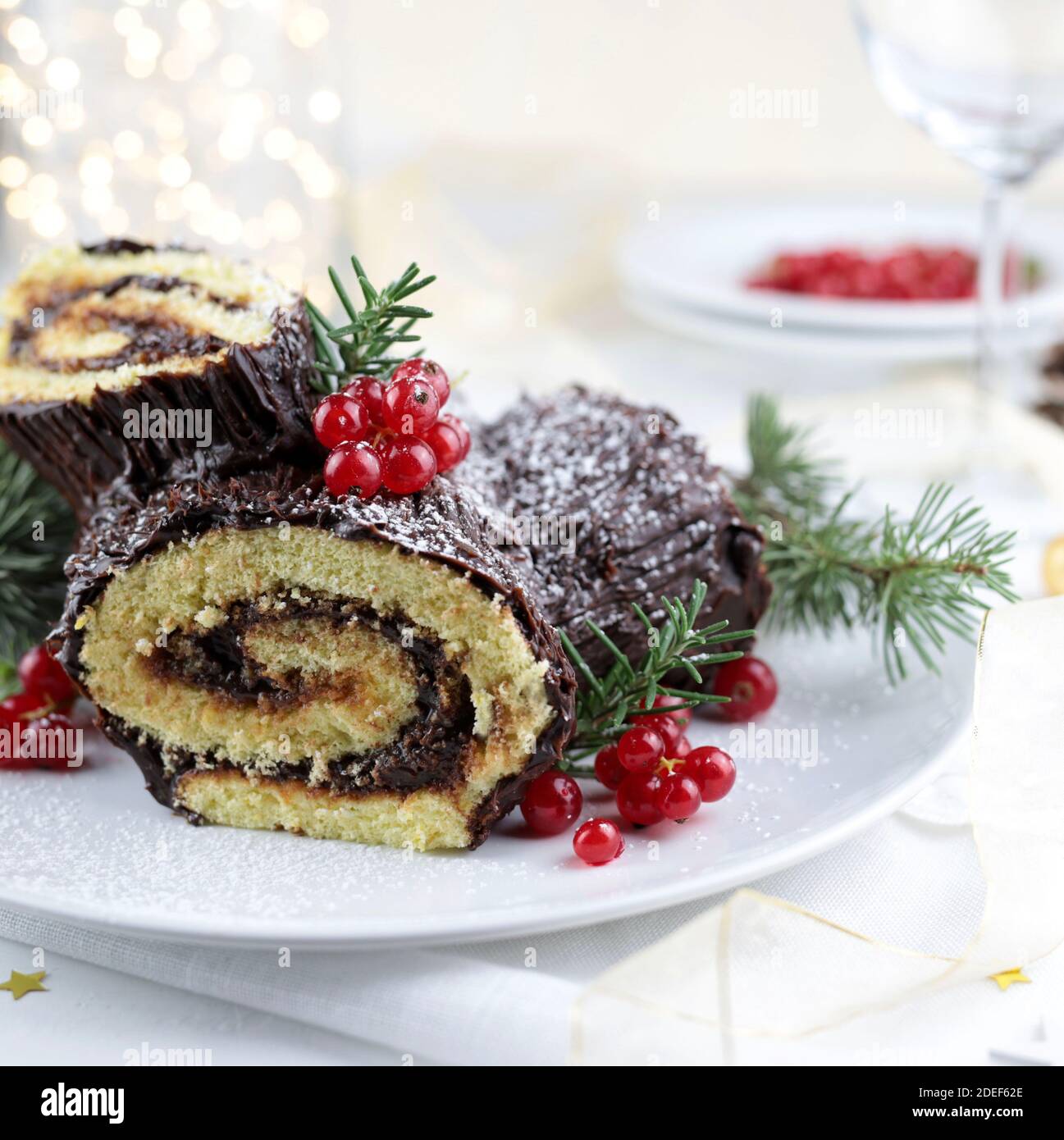 Chocolate Christmas Yule Log, Buche de Noel on white background. Christmas decorations Stock Photo