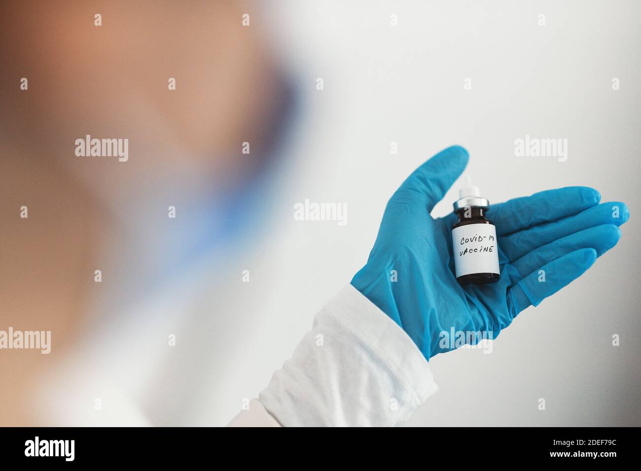 Female doctor holding in her hand coronavirus vaccine - covid-19 health concept Stock Photo