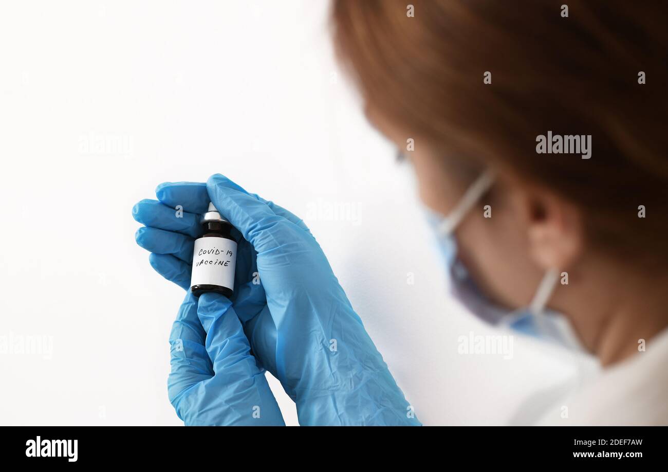 Female doctor holding in her hand coronavirus vaccine - covid-19 health concept Stock Photo