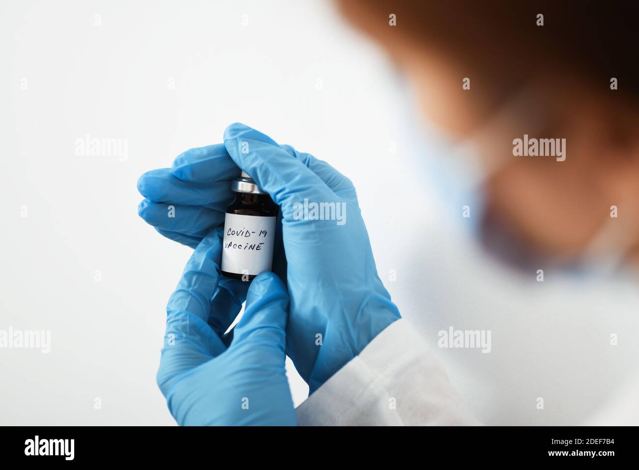 Female doctor holding in her hand coronavirus vaccine - covid-19 health concept Stock Photo