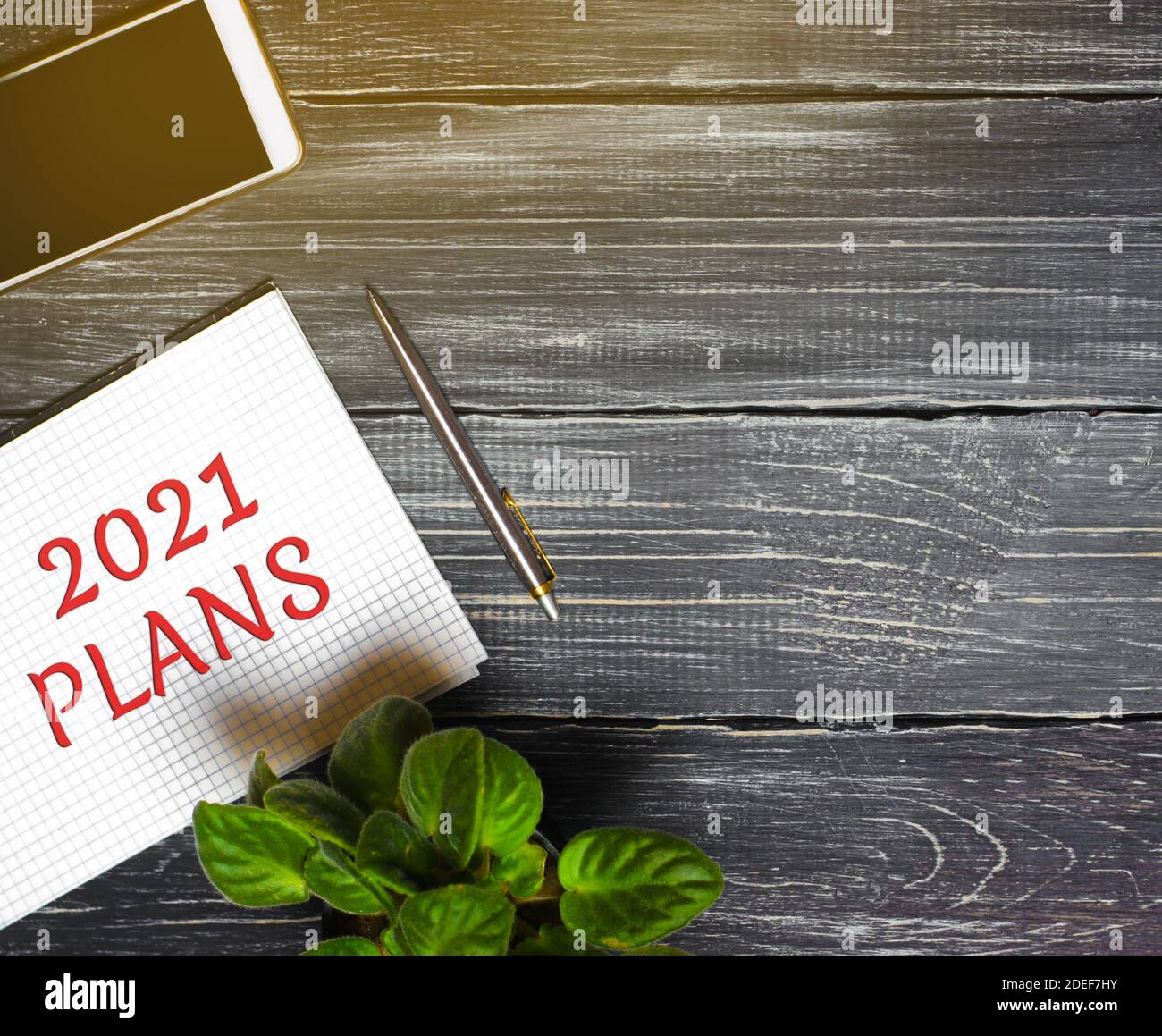 2021 Plans concept. Desktop with notebook, phone, pen. Planning goals, plans and tasks. New business ideas. Setting goal, target. Motivation, inspirat Stock Photo