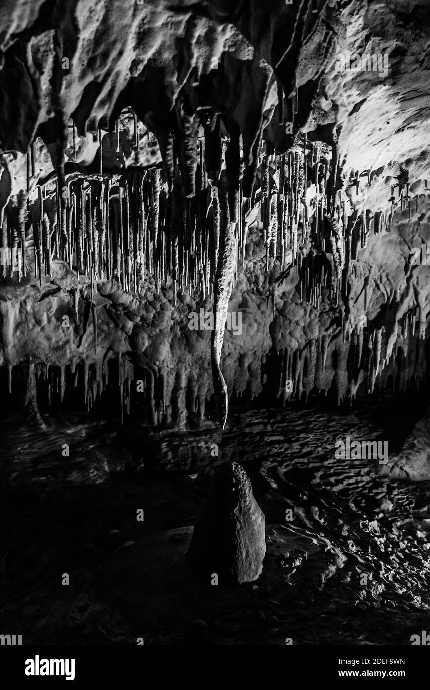 Illuminated picturesque karst rock formations in Balcarka Cave, Moravian Karst, Czech: Moravsky Kras, Czech Republic. Black and white image. Stock Photo