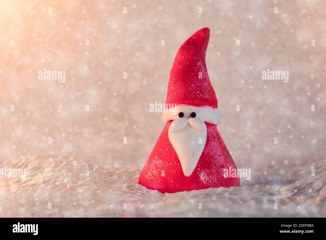 Santa claus figurine in snowy landscape. Greeting christmas card, seasonal background. Stock Photo