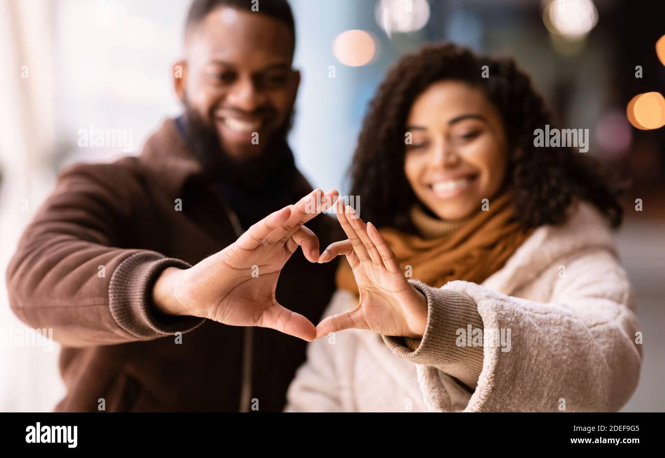 Portrait of black couple making heart shape with hands Stock Photo - Alamy