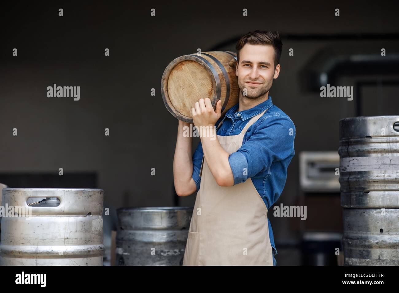 Strong handsome male brewery worker and industrial production Stock Photo