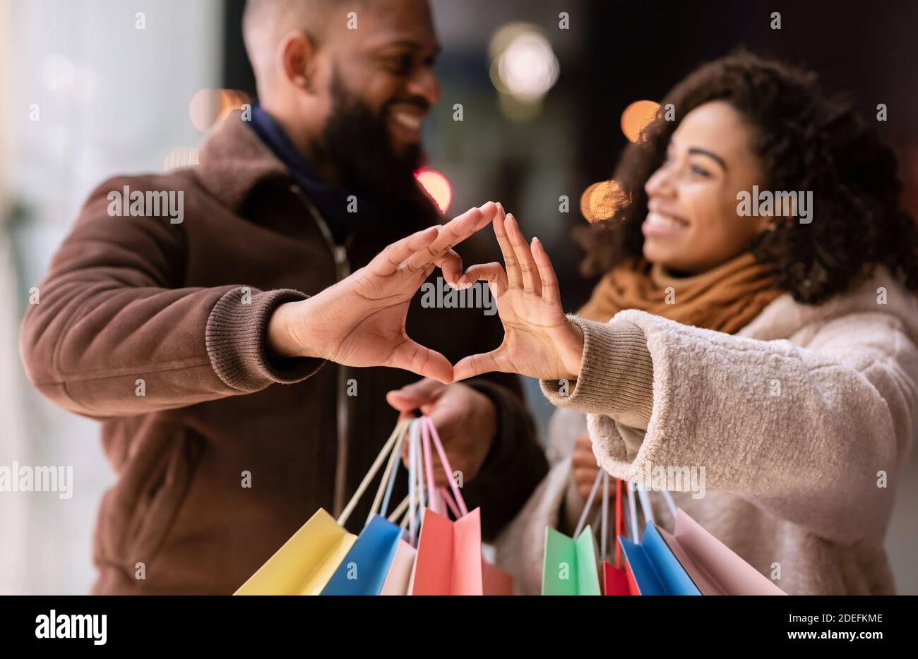 Portrait of black couple making heart shape with hands Stock Photo - Alamy