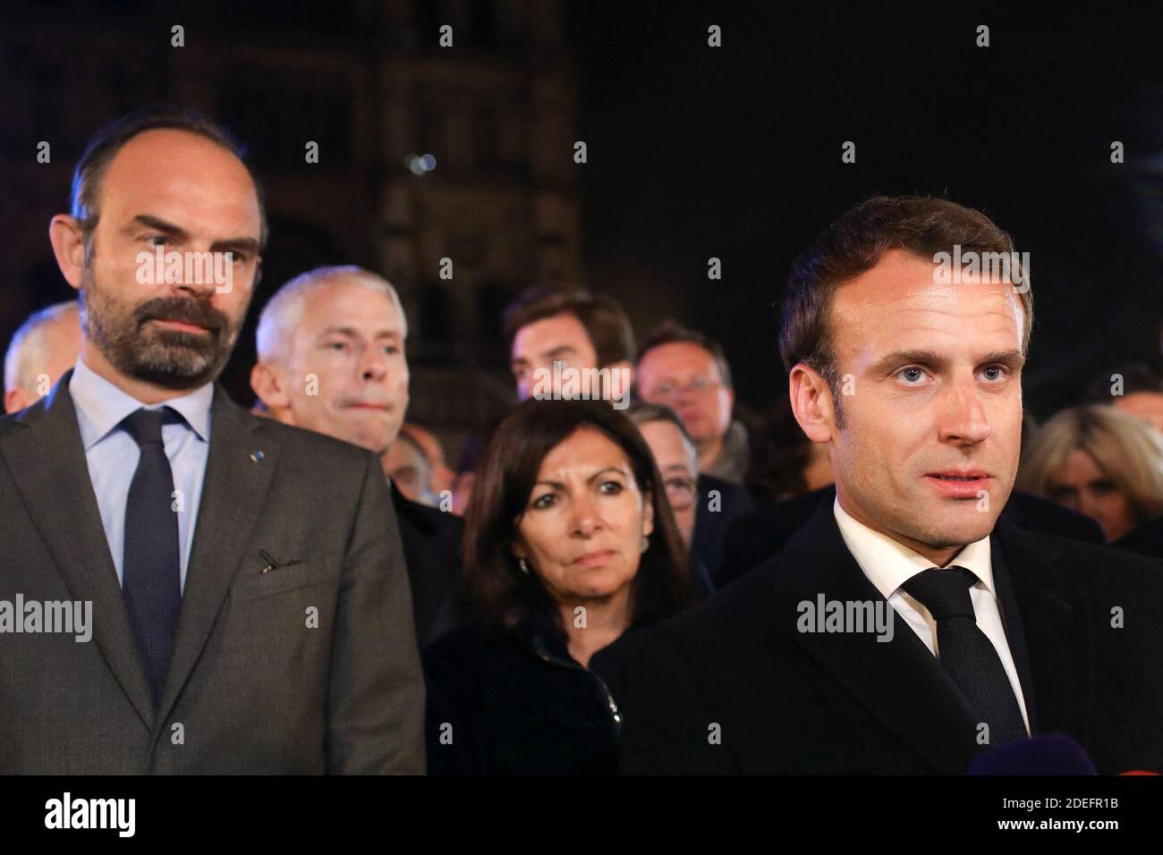 French President Emmanuel Macron is accompanied by Mayor of Paris Anne Hidalgo, French Prime Minister Edouard Philippe, French Culture Minister Franck Riester, and Archbishop of Paris Michel Aupetit, as he speaks at Notre-Dame Cathedral in Paris on April 15, 2019, after a fire engulfed the building. A fire broke out at the landmark Notre-Dame Cathedral in central Paris, potentially involving renovation works being carried out at the site, the fire service said.Images posted on social media showed flames and huge clouds of smoke billowing above the roof of the gothic cathedral, the most visited Stock Photo