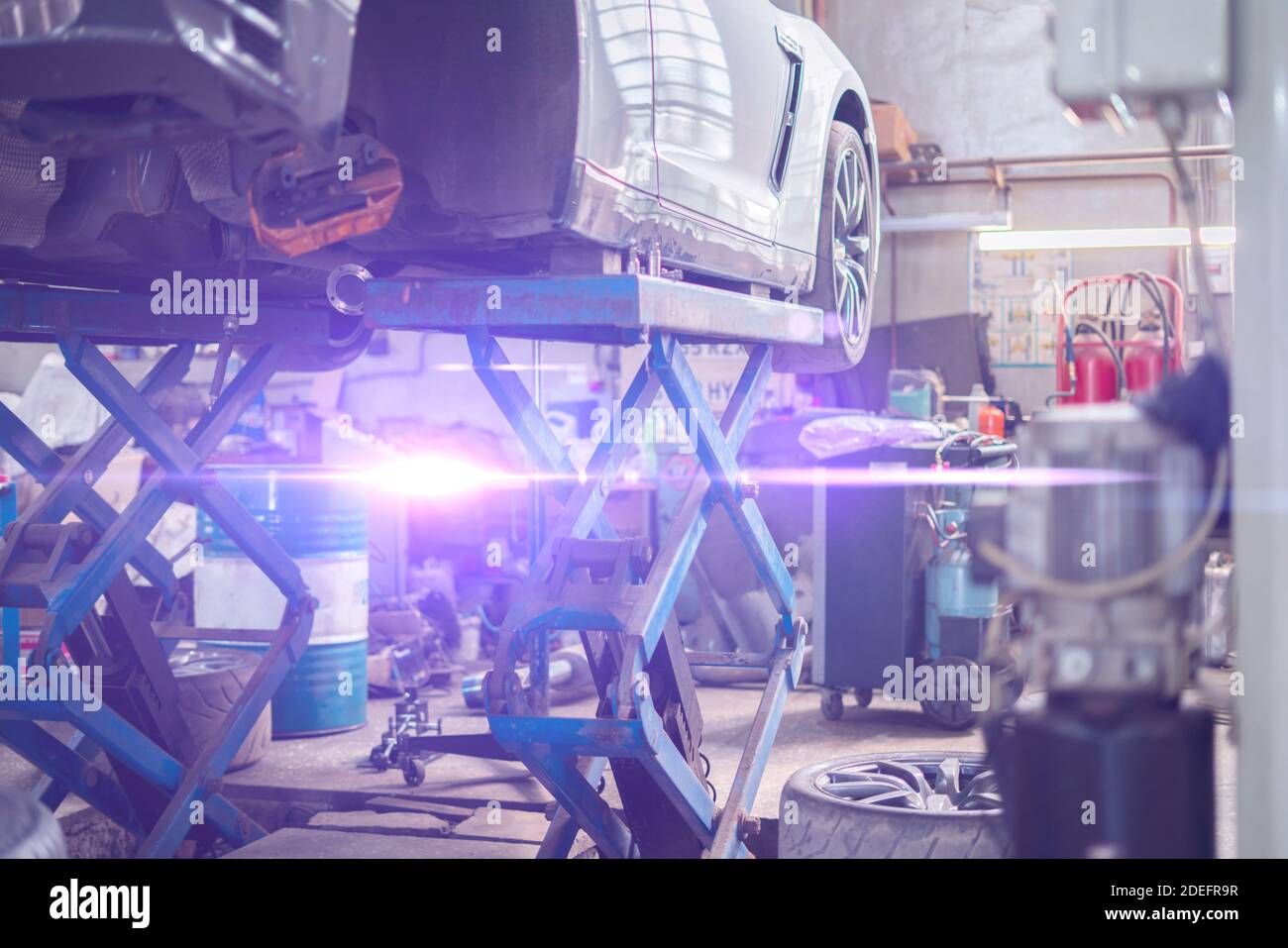a car standing on a lift station in the repair service garage, workshop ...