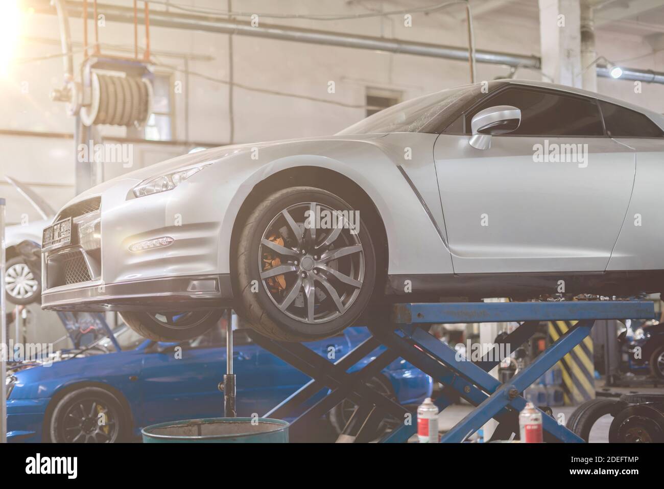 a car standing on a lift station in the repair service garage, workshop ...