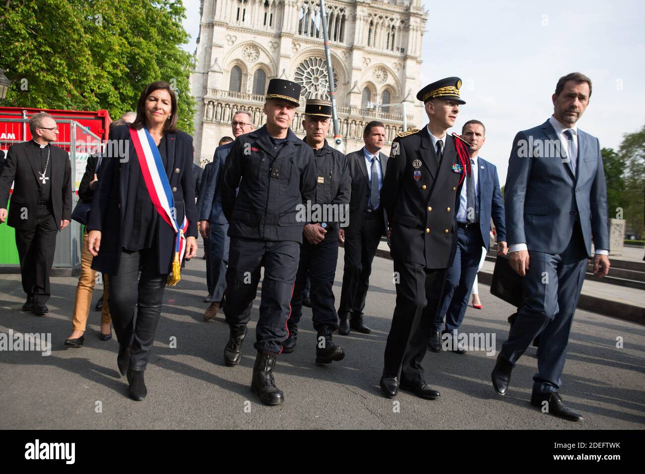 French Interior Minister Christophe Castaner (R), Paris prefect Didier Lallement (2R), Paris mayor Anne Hidalgo (L), and other officials walk by Notre Dame cathedral on April 18, 2019 in Paris. France paid a daylong tribute on April 18, 2019 to the Paris firefighters who saved Notre Dame Cathedral from collapse, while construction workers rushed to secure an area above one of the church's famed rose-shaped windows and other vulnerable sections of the fire-damaged landmark. Photo by Raphael Lafargue/ABACAPRESS.COM Stock Photo