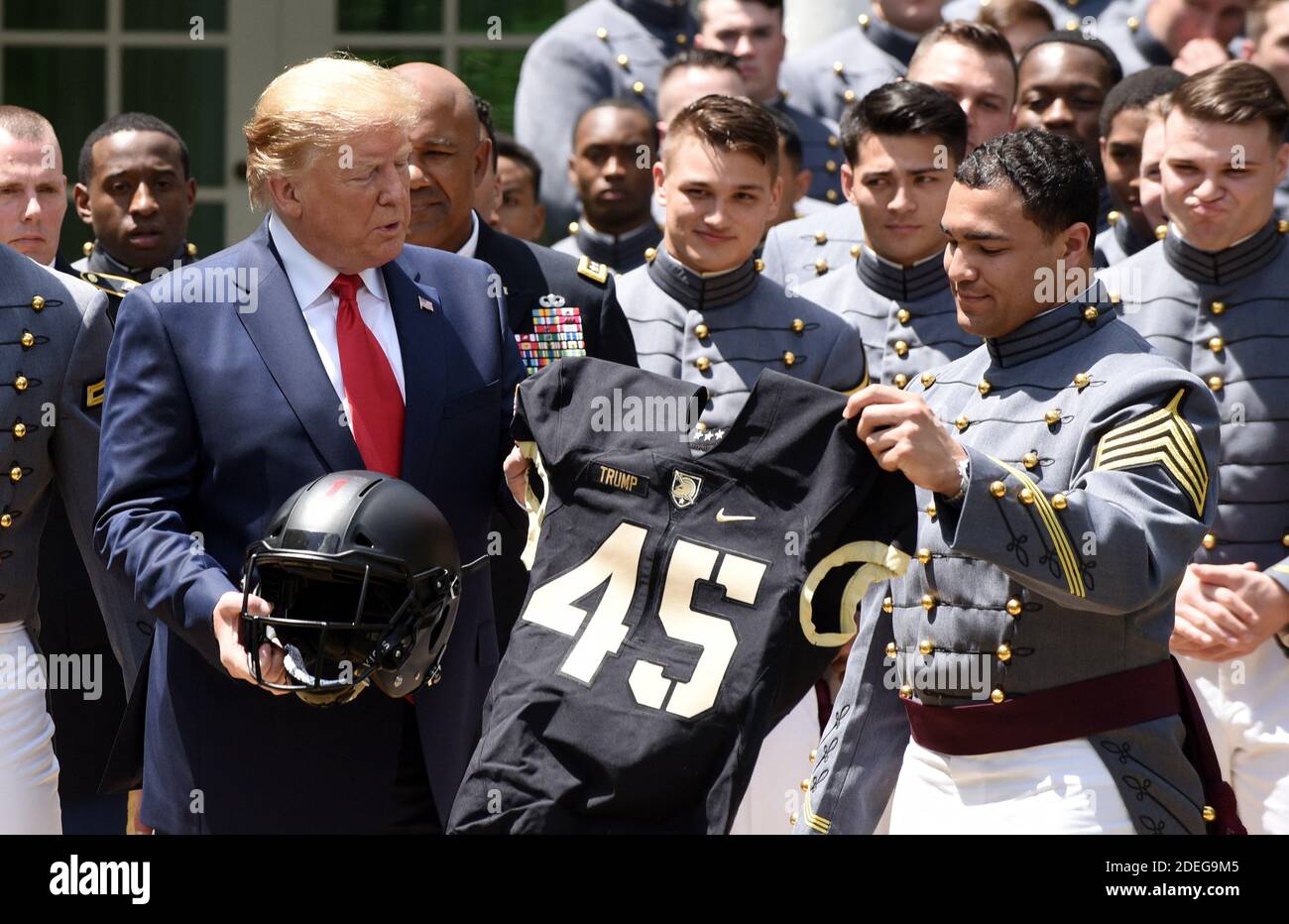 U.S. President Donald Trump is presented with a jersey and a helmet by  running back Darnell Woolfolk (R) during an event with the Army Black  Knights football team from the U.S. Military