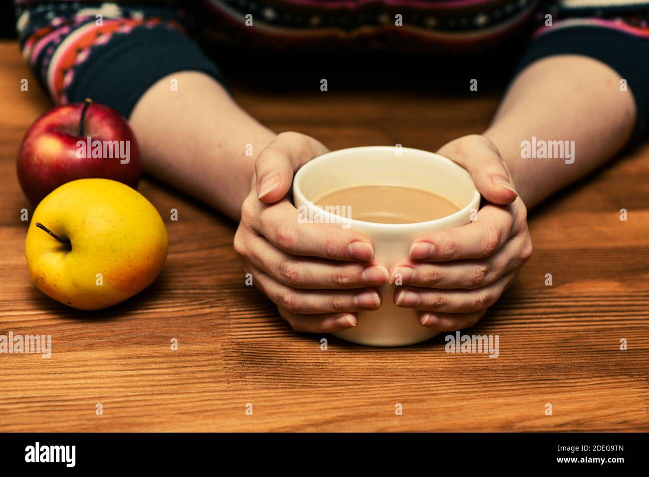 Young woman holding hot cocoa or coffee c. Autumn or winter moody weekend, New Year and Christmas background. Lazy day, quarantine, stay home, cozy Stock Photo