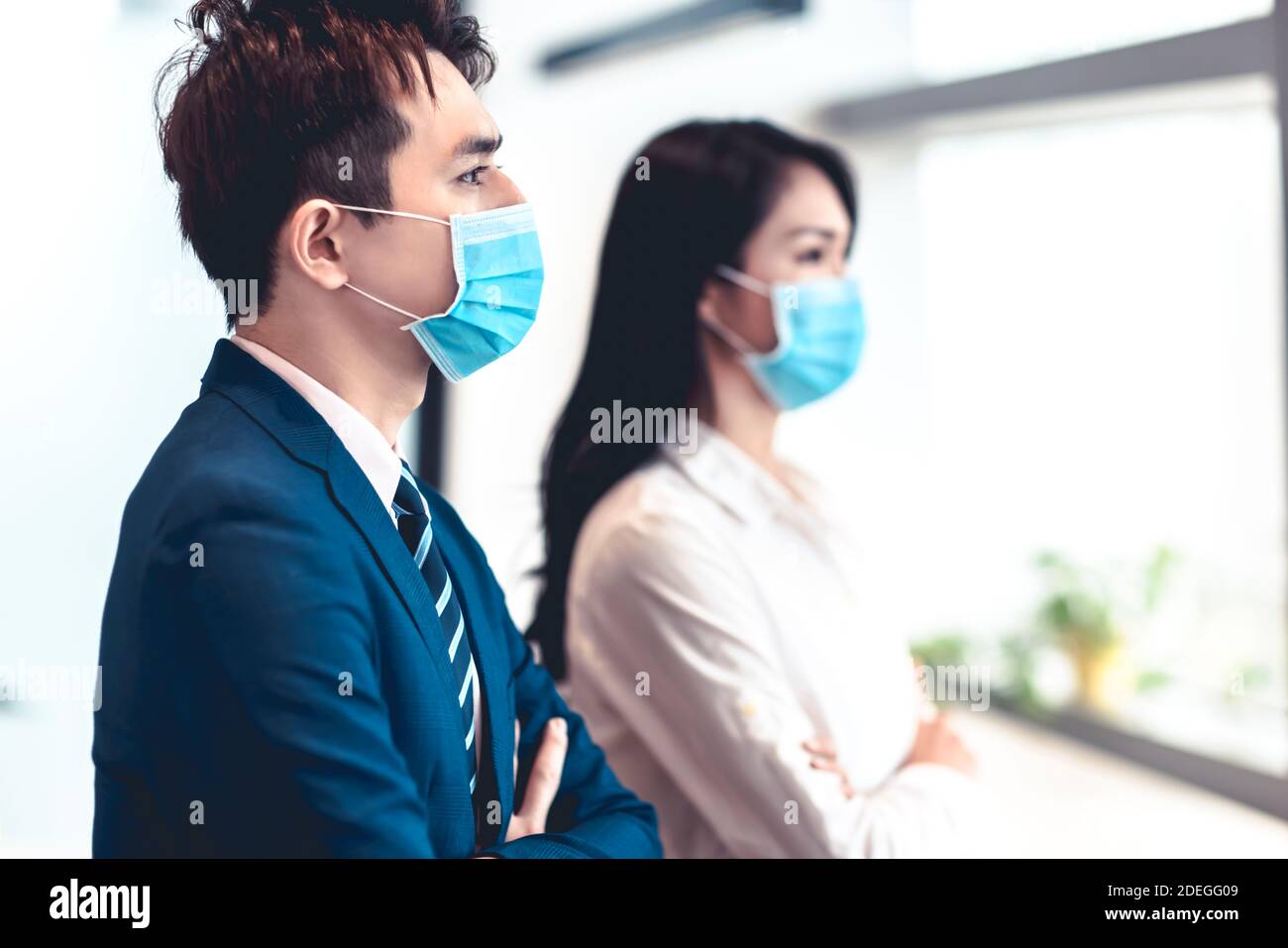 Business man and woman wearing medical face mask while working in office Stock Photo