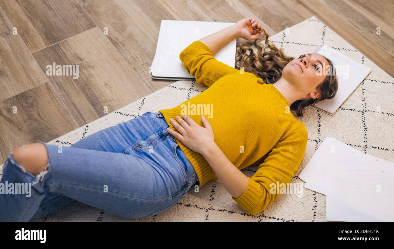 Young woman exhausted from work lying on the floor Stock Photo Alamy
