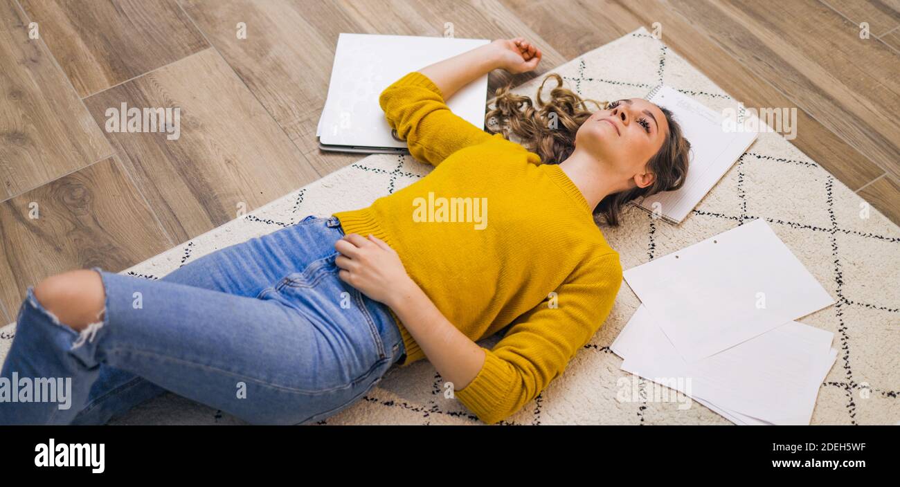 Young woman exhausted from work lying on the floor Stock Photo Alamy