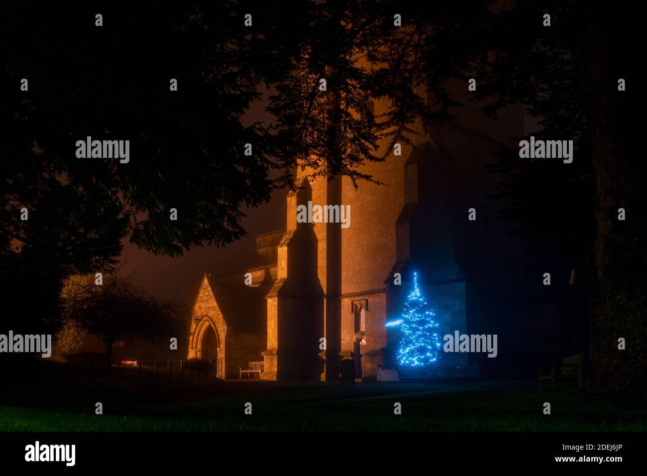 St Edwards church gates and christmas tree lights in the mist at night